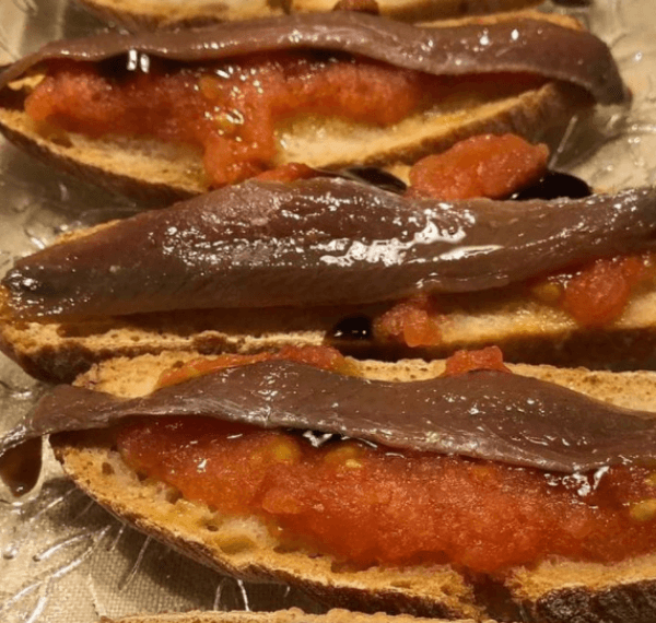 Tostas de anchoas y tomate sobre biscote casero